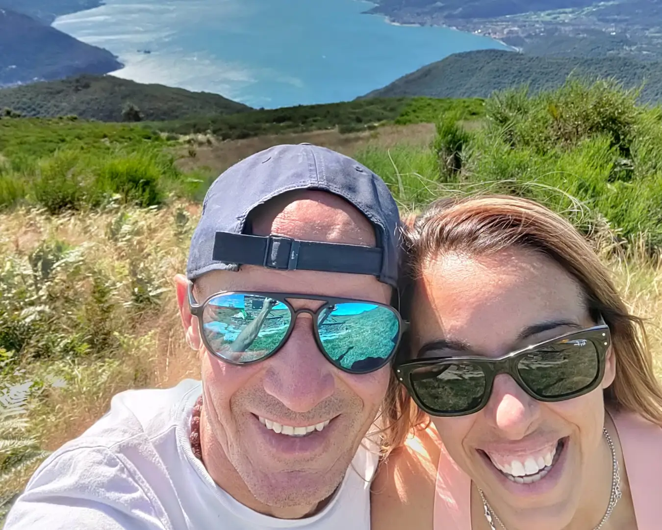 Chiara De Servi abbracciata al suo compagno, entrambi sorridenti durante una giornata estiva al lago